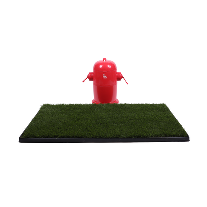 Red fire hydrant trash can sitting behind a rectangle of real grass with a black tray on a white background