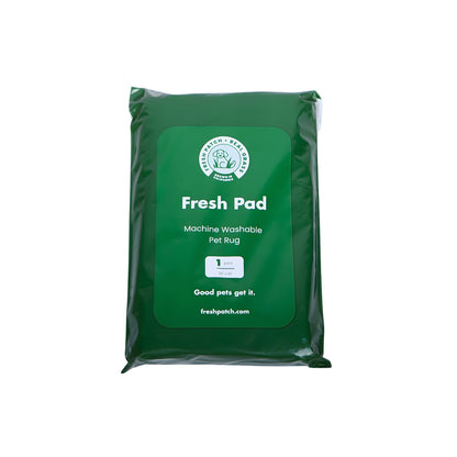 Green package of Fresh Pad machine washable pet rug on a white background