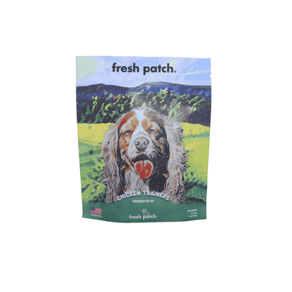 Dog treat package with a mountainous landscape and a dog's face on the label, featuring the brand 'fresh patch'.